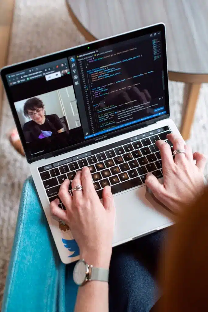 person-using-gray-laptop-3861964 Person coding on a laptop during a video conference, showcasing remote work.